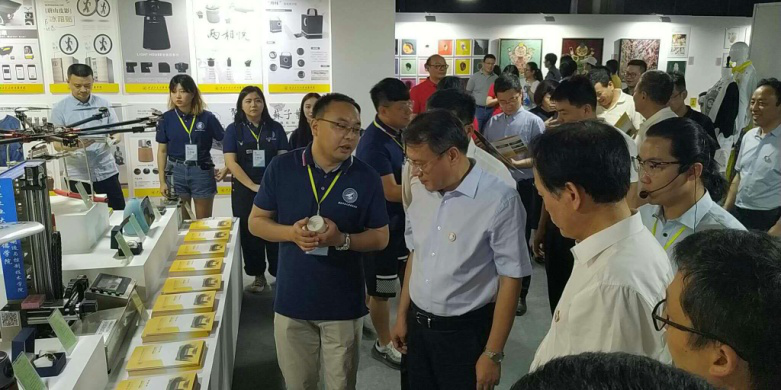 西安市委常委、副市長高杲在青博會聽取明德學院師生講解設計作品